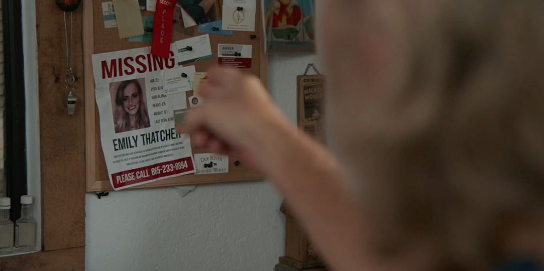 Cal points toward Emily's missing poster